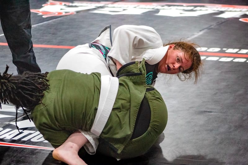 A woman controlling an opponent on the competition mat